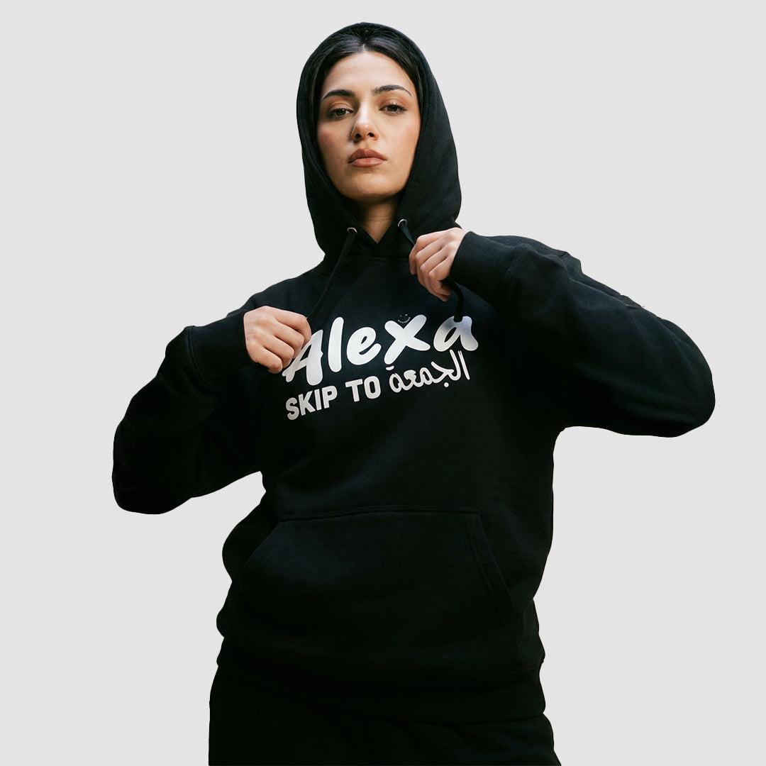 ragazza indossa felpa unisex nera con cappuccio e scritta bianca in inglese ed arabo alexa skip to الجمعة - Totally Random®