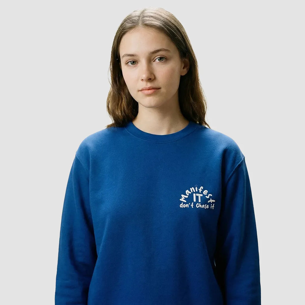 ragazza indossa felpa unisex girocollo blu con scritta bianca in inglese manifest it don't chase it - Totally Random®