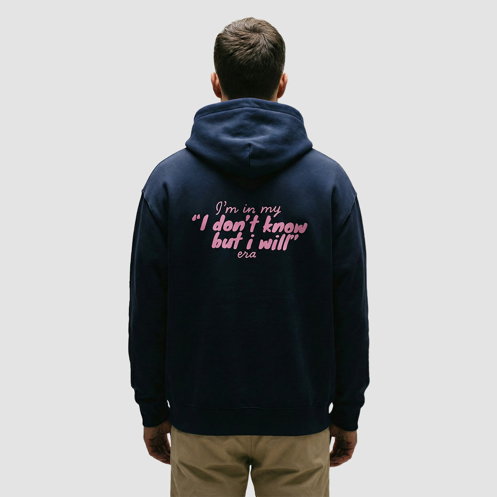 ragazzo indossa felpa unisex oversize blu navy con scritta rosa in inglese sulla schiena im in my i don't know but i will era - Totally Random®