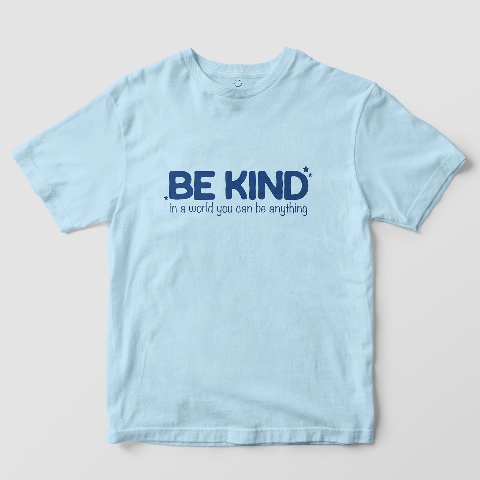 Mockup maglietta unisex girocollo azzurra in cotone biologico e scritta blu navy “Be Kind in a world you can be anything” Totally Random