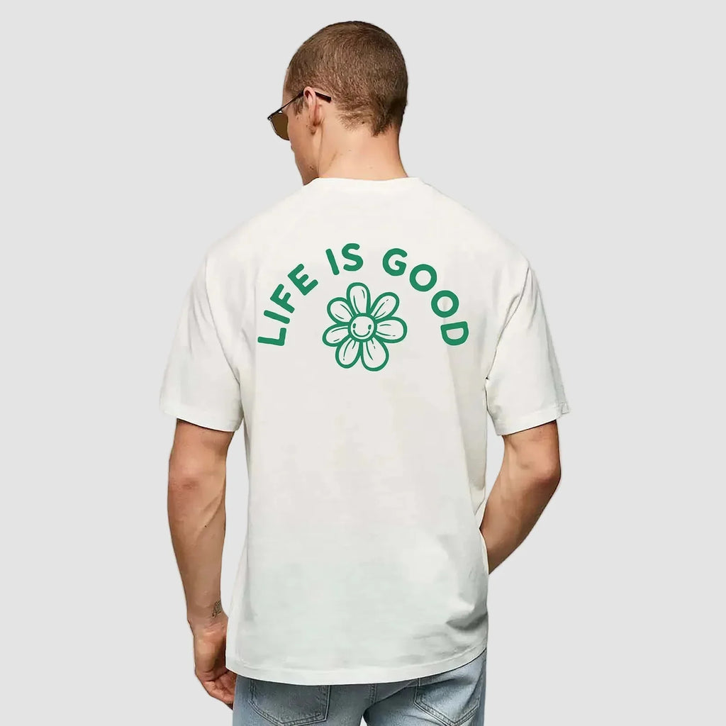 uomo indossa maglietta unisex bianca con icone di fiore e scritta verde sulla schiena Life Is Good - Totally Random®