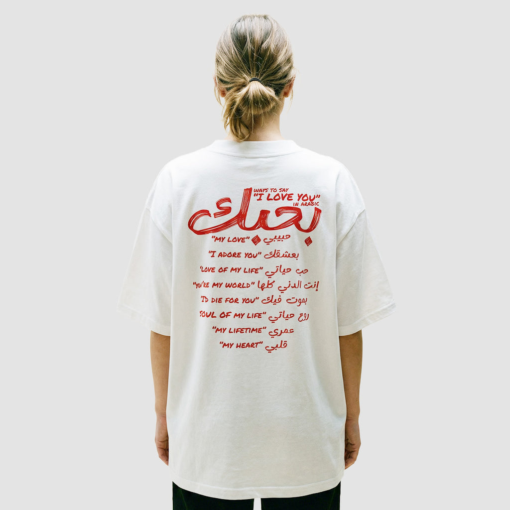ragazza indossa maglietta unisex oversize bianca con scritta rossa in inglese e arabo ways to say i love you in arabic - Totally Random®
