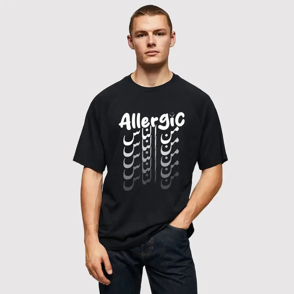 uomo indossa maglietta unisex nera con scritta inglese e arabo bianca allergic من الناس - Totally Random®