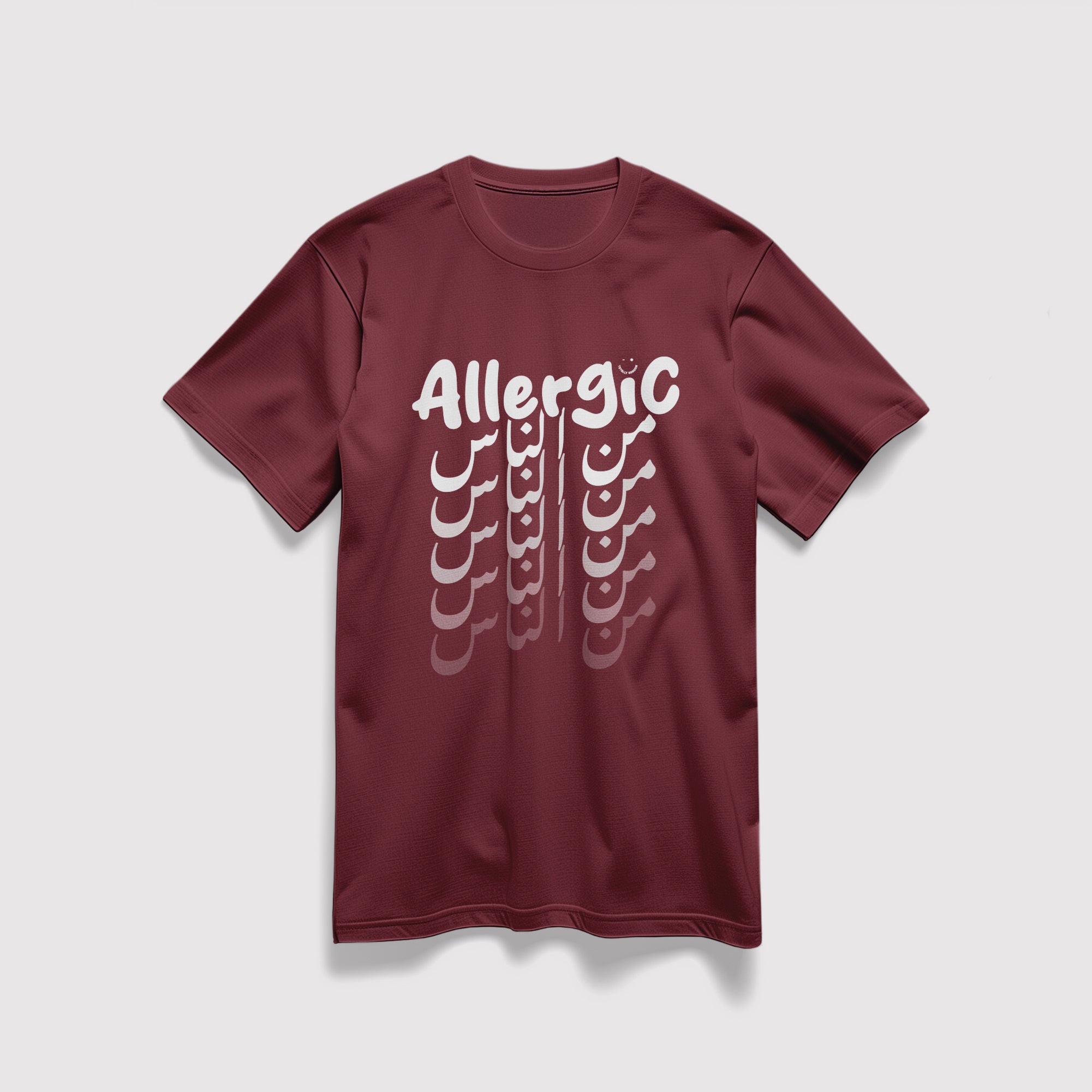 Mockup maglietta unisex girocollo bordeaux in cotone biologico e scritta bianca “Allergic من الناس” Totally Random