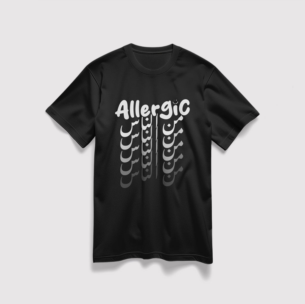 Mockup maglietta unisex girocollo nera in cotone biologico e scritta bianca “Allergic من الناس” Totally Random