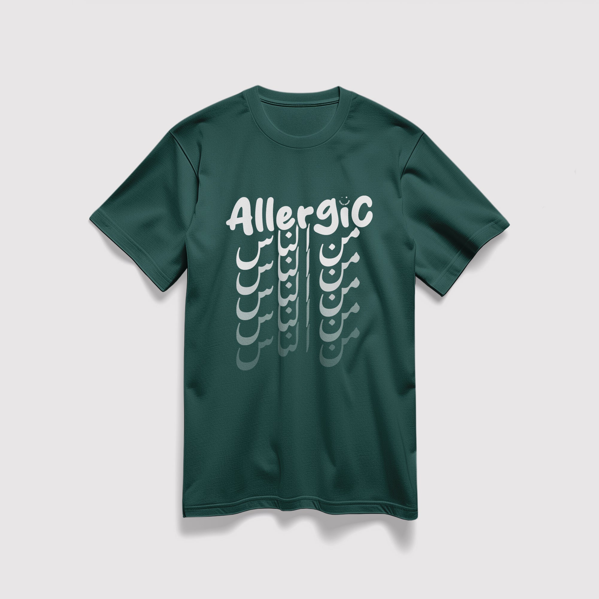 Mockup maglietta unisex girocollo verde in cotone biologico e scritta bianca “Allergic من الناس” Totally Random
