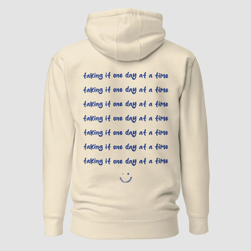 mockup retro felpa unisex beige con cappuccio e scritta blu in inglese sulla schiena taking it one day at a time - Totally Random®