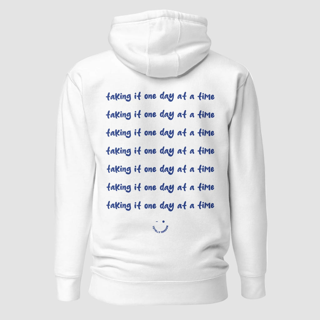mockup retro felpa unisex bianca con cappuccio e scritta blu in inglese sulla schiena taking it one day at a time - Totally Random®