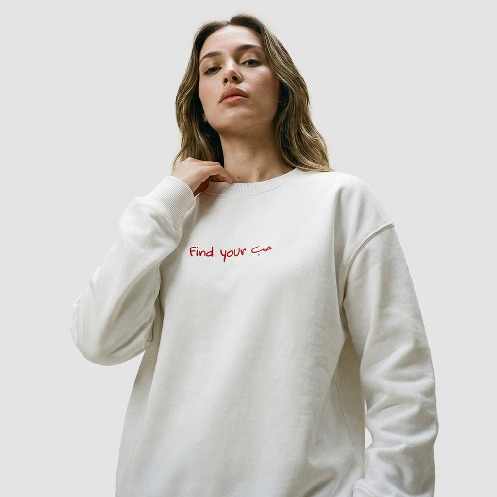 ragazza indossa felpa unisex oversize bianca con scritta rossa in inglese e arabo find your love - Totally Random®