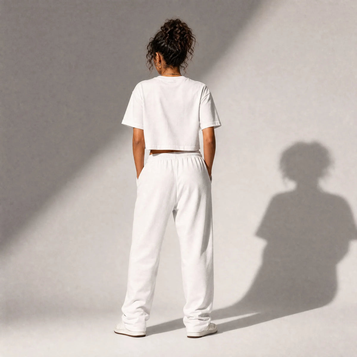 vista posteriore di una donna con outfit streetwear che indossa una cropped t-shirt bianco totally random con design today مالي خلق