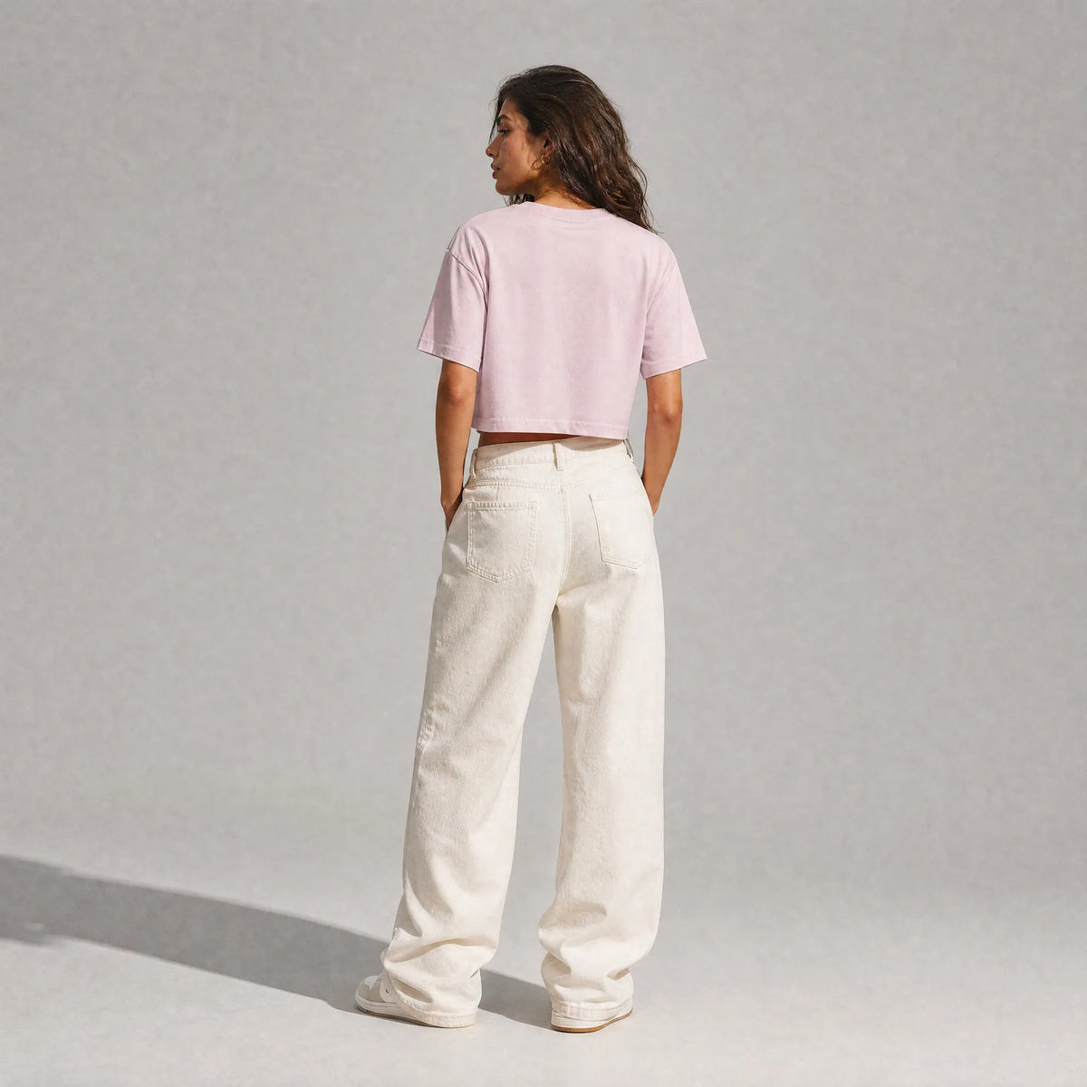 vista posteriore di una donna con outfit streetwear che indossa una cropped t-shirt rosa totally random con design today مالي خلق