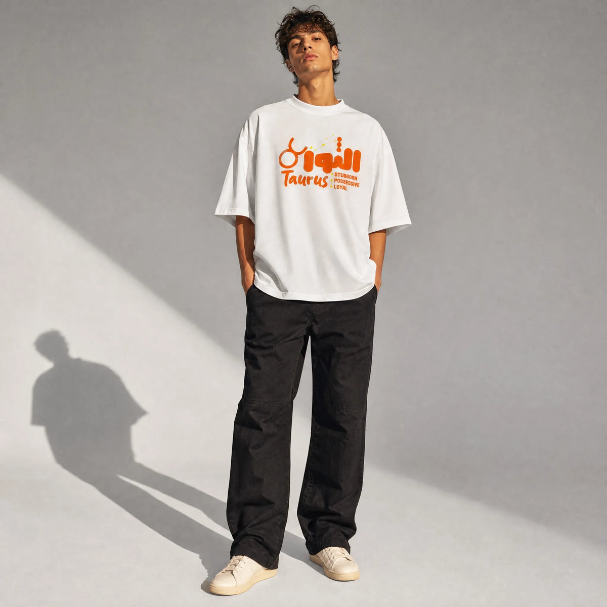 uomo con outfit streetwear che indossa una t-shirt bianco oversize totally random con design oroscopo taurus الثور, stubborn possessive loyal