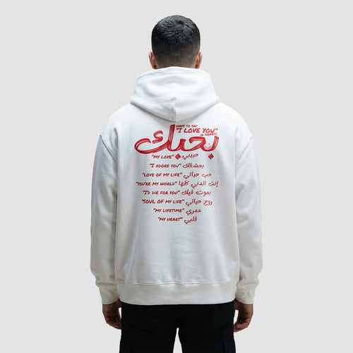 uomo indossa felpa unisex oversize con cappuccio bianca e scritta rossa in inglese e arabo ways to say i love you in arabic - Totally Random®
